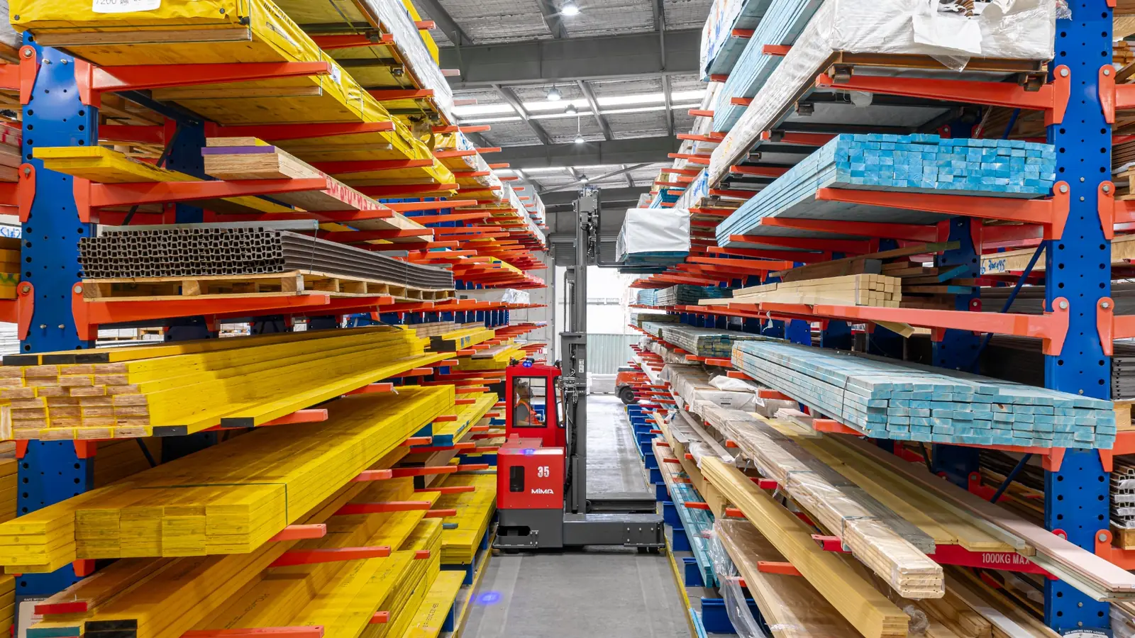 MiMA multi-directional forklift stacking long materials in a narrow warehouse aisle
